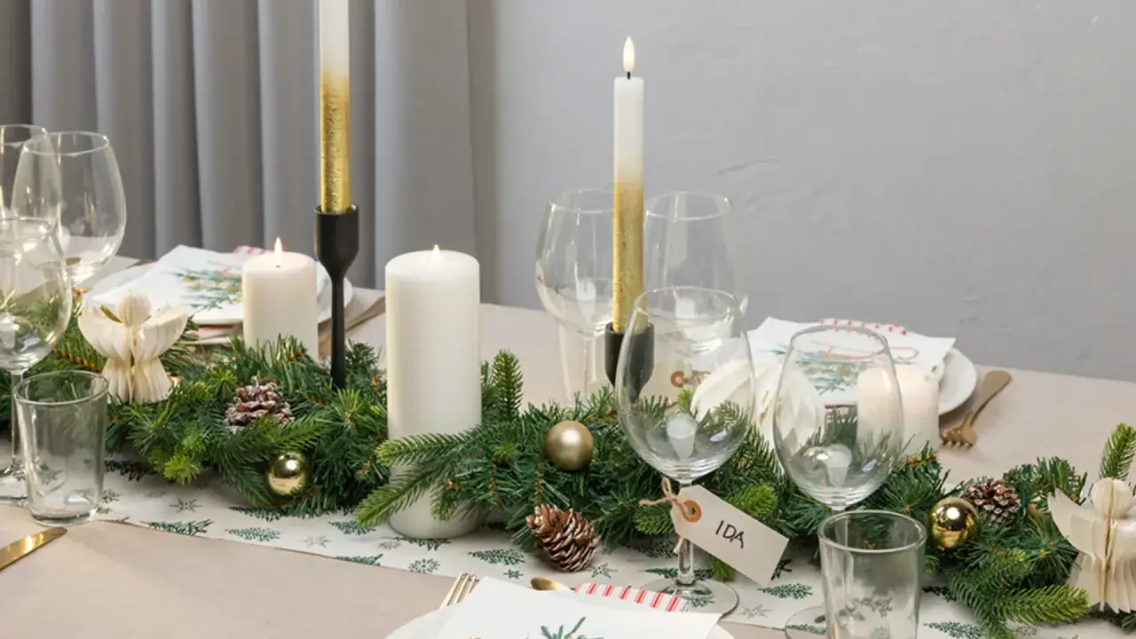 Vacker juldukning med granris, ljus och julgranskulor. En fin juldukning som skapar stämning.