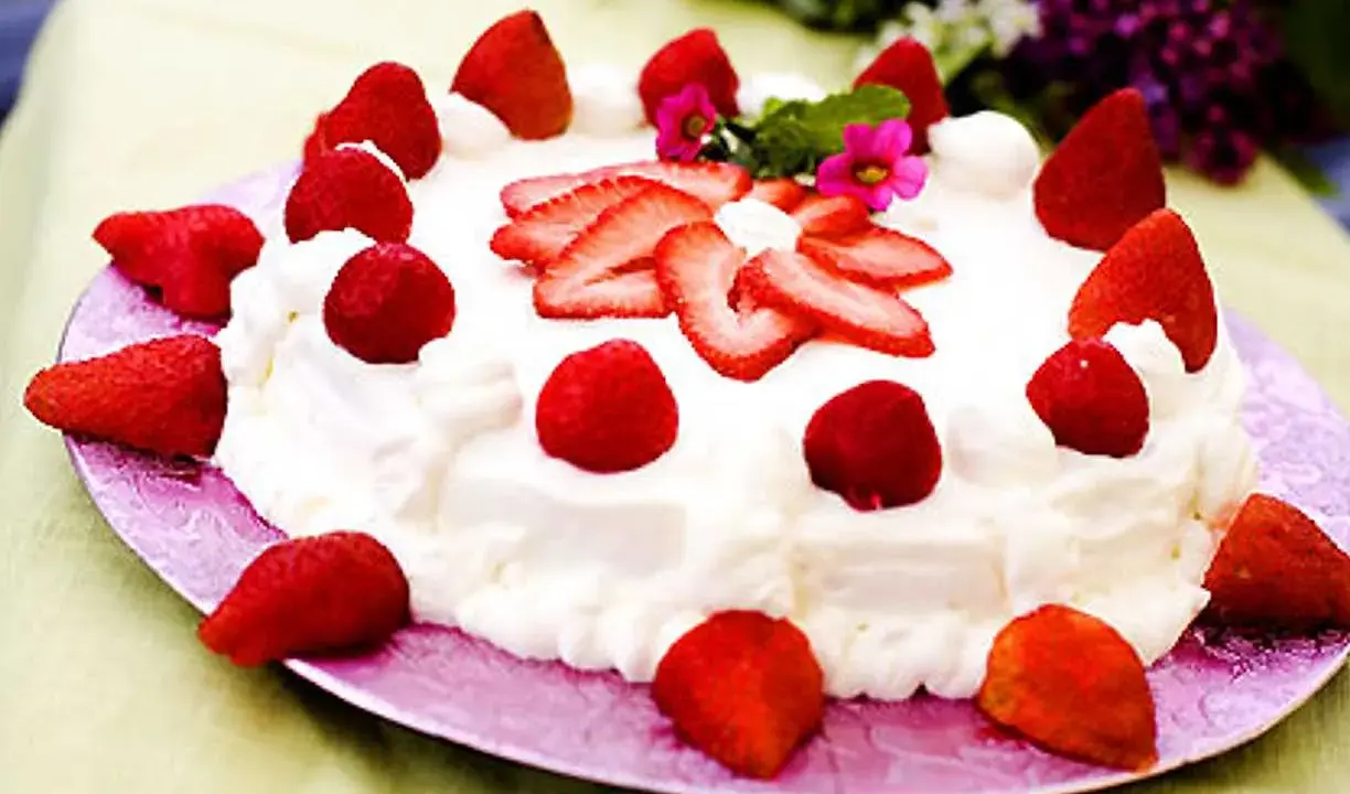 En härlig jordgubbstårta med vispgrädde, perfekt för ett sommarfika. Ett enkelt tårta recept att följa.