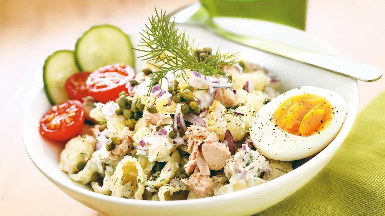 En härlig tonfisksallad med pasta, toppad med kapris, rödlök och dill. Serveras med halvt kokt ägg och körsbärstomater.