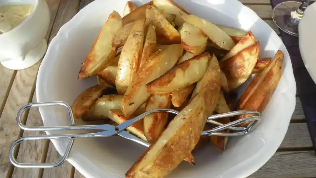 En skål med gyllene klyftpotatis i ugn, redo att serveras med en sallad och dipp. Perfekt tillbehör!