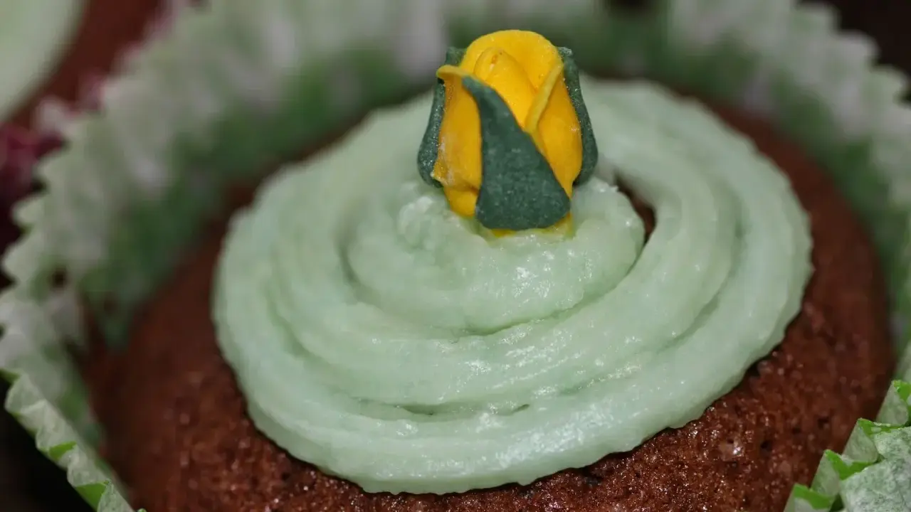 Chokladmuffins med ljusgrön frosting och en gul ros. Ett enkelt frosting recept för dekoration.