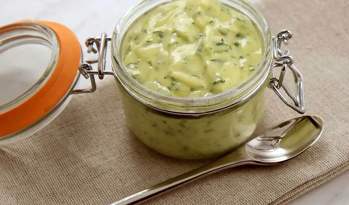 En burk med krämig bearnaisesås, perfekt för ditt nästa bearnaise recept. En sked ligger bredvid.