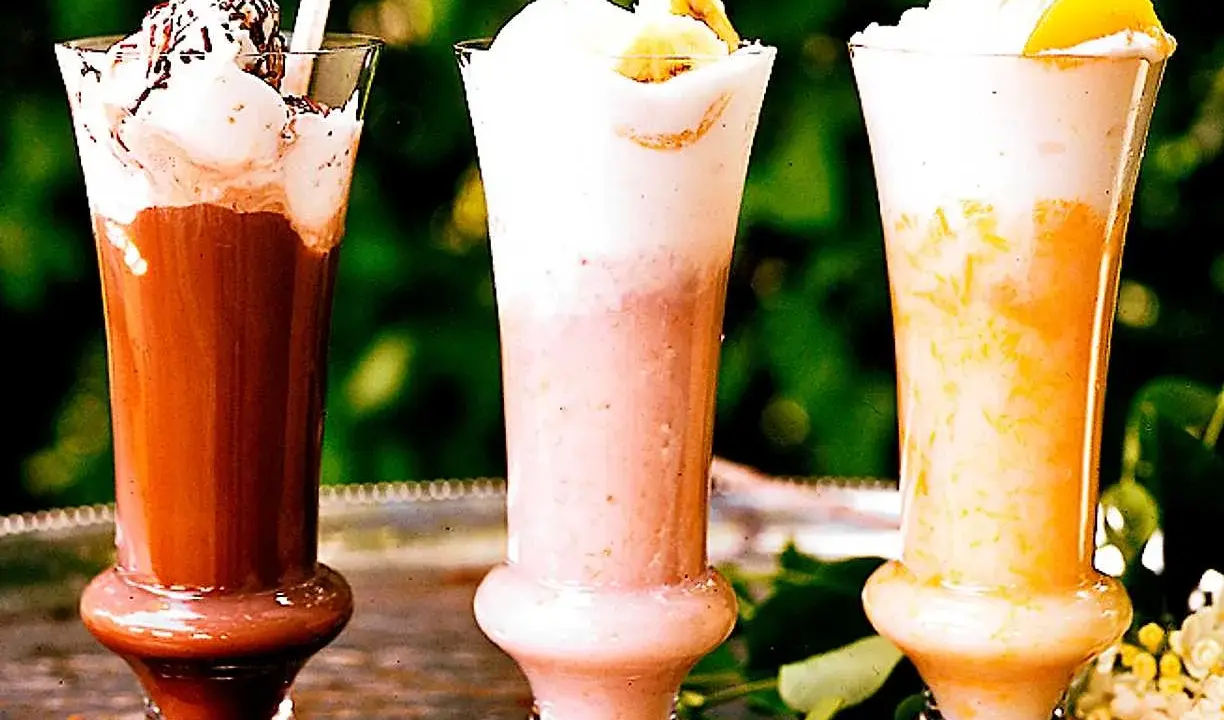 Tre läckra milkshakes i glas: choklad, jordgubb och aprikos. Perfekt för ett somrigt milkshake recept!