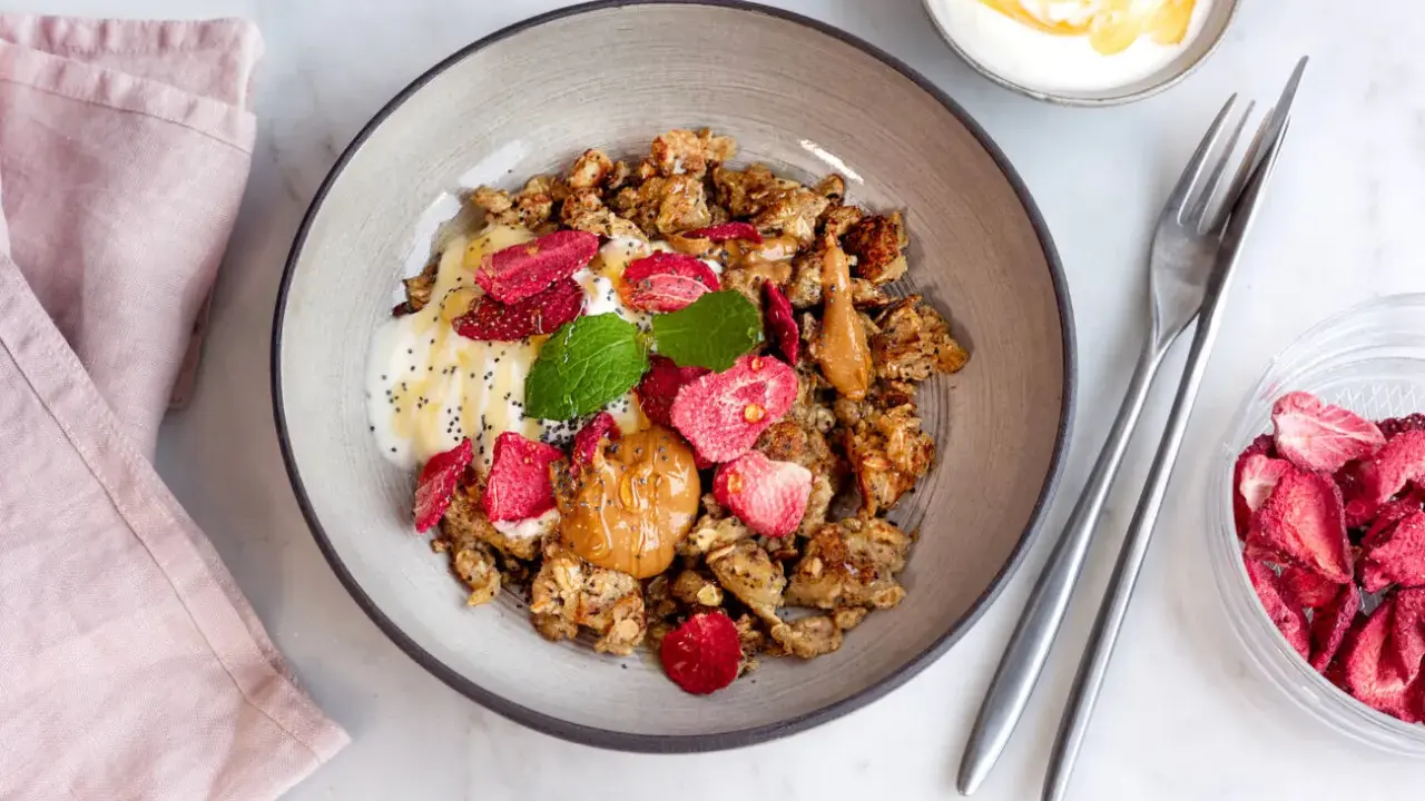 En skål med krämig yoghurt, krispig granola, jordgubbar och en klick jordnötssmör. En perfekt start på dagen med scrambled oats!