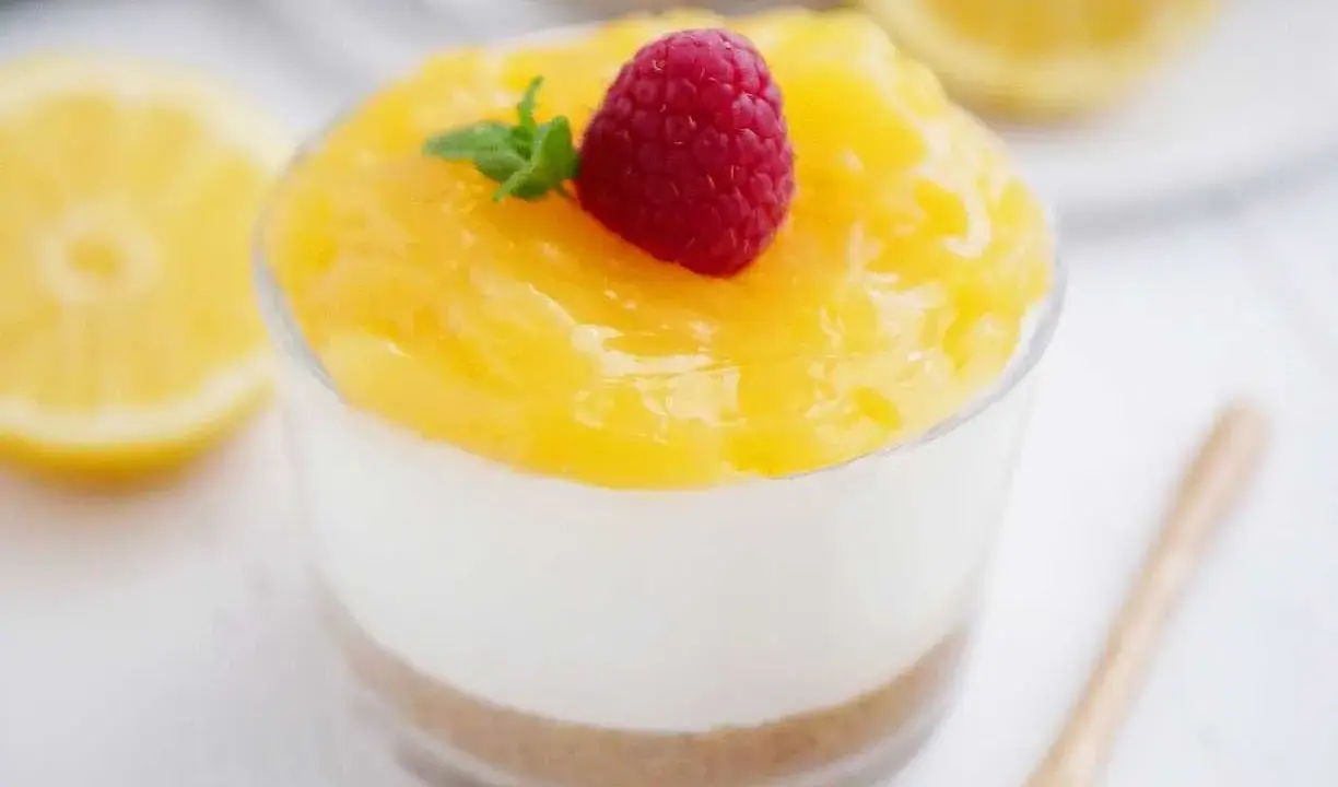 Enkel dessert i glas med citronsmak, toppad med hallon och mynta. En perfekt avslutning på måltiden.