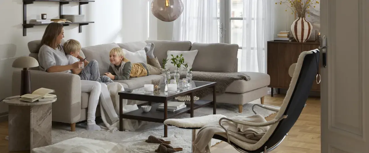 Familj myser i soffan. För att skydda tyget och göra det lättare att rengöra, kan man impregnera soffan.