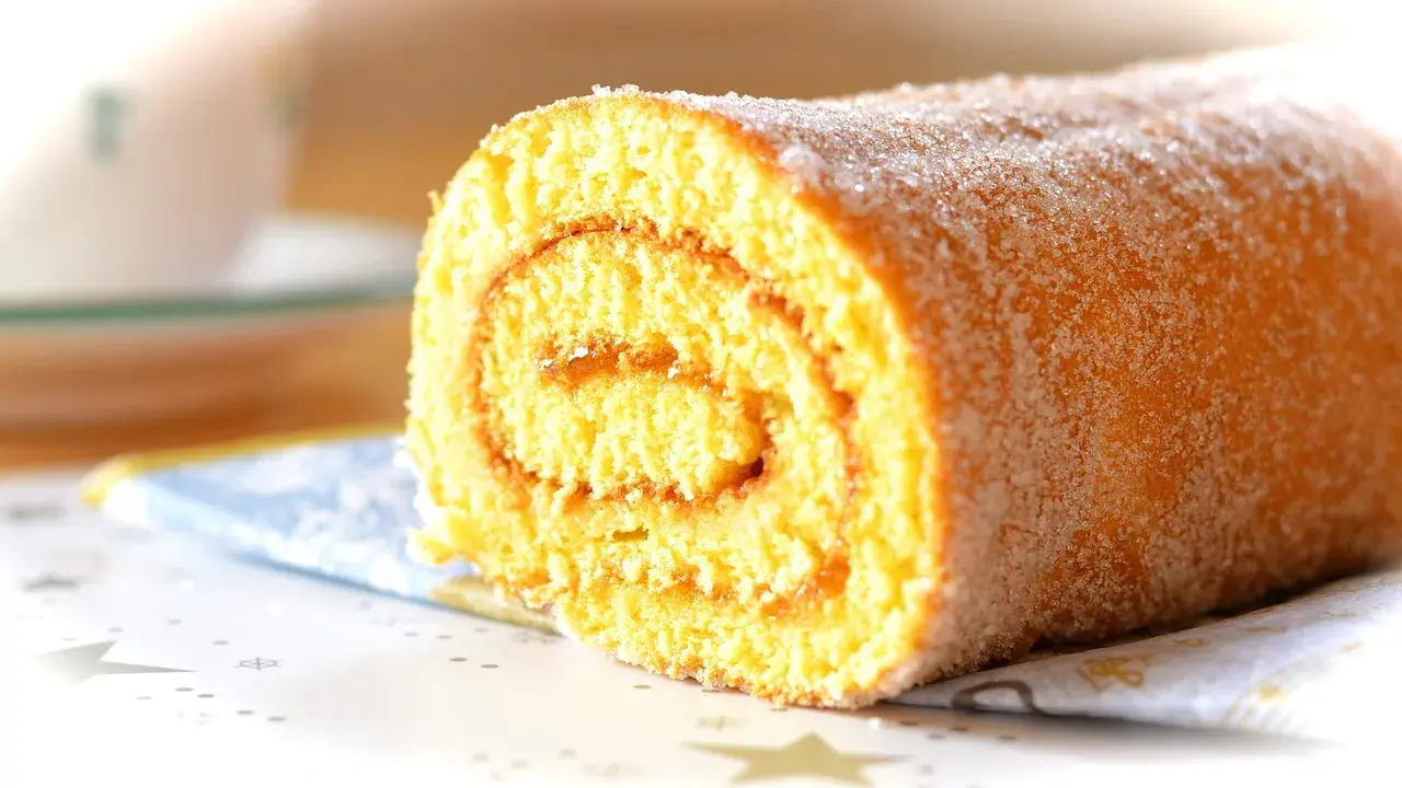 En sockerströdd rulltårta, perfekt för ett enkelt rulltårta recept.