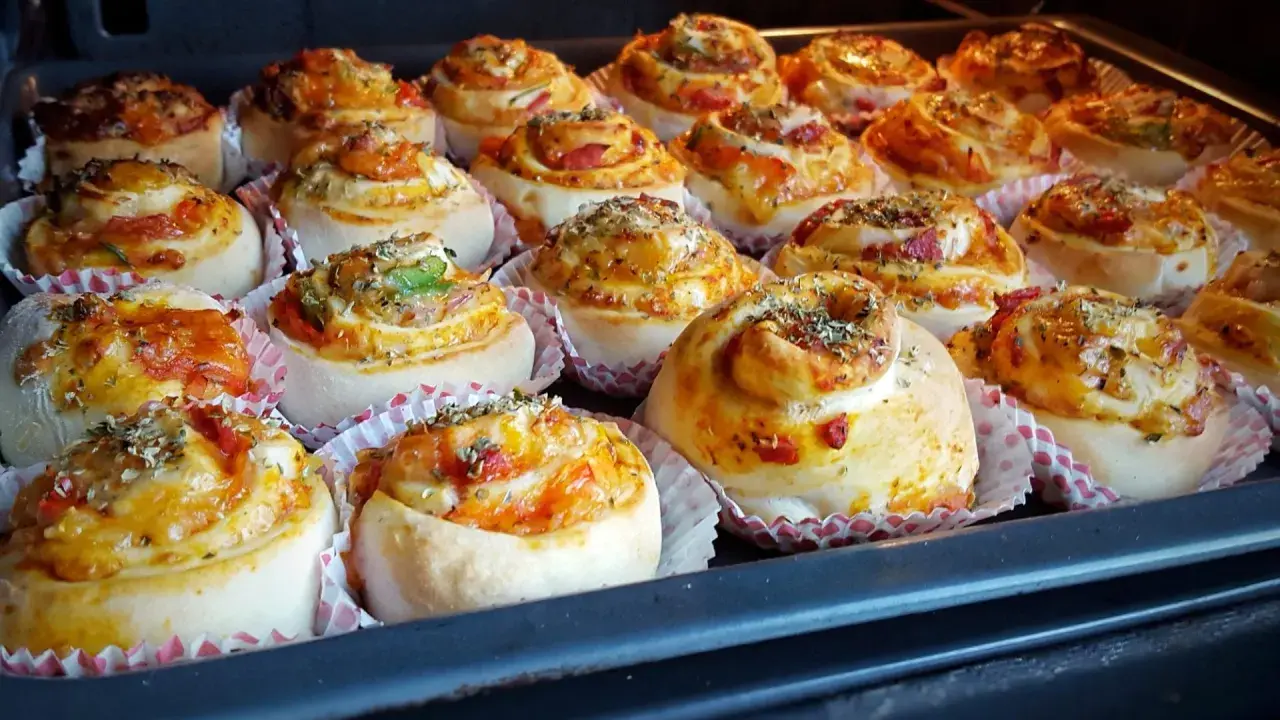 Nybakade pizzabullar med ost och grönsaker, redo för ugnen. Ett perfekt pizzabullar recept för hela familjen.