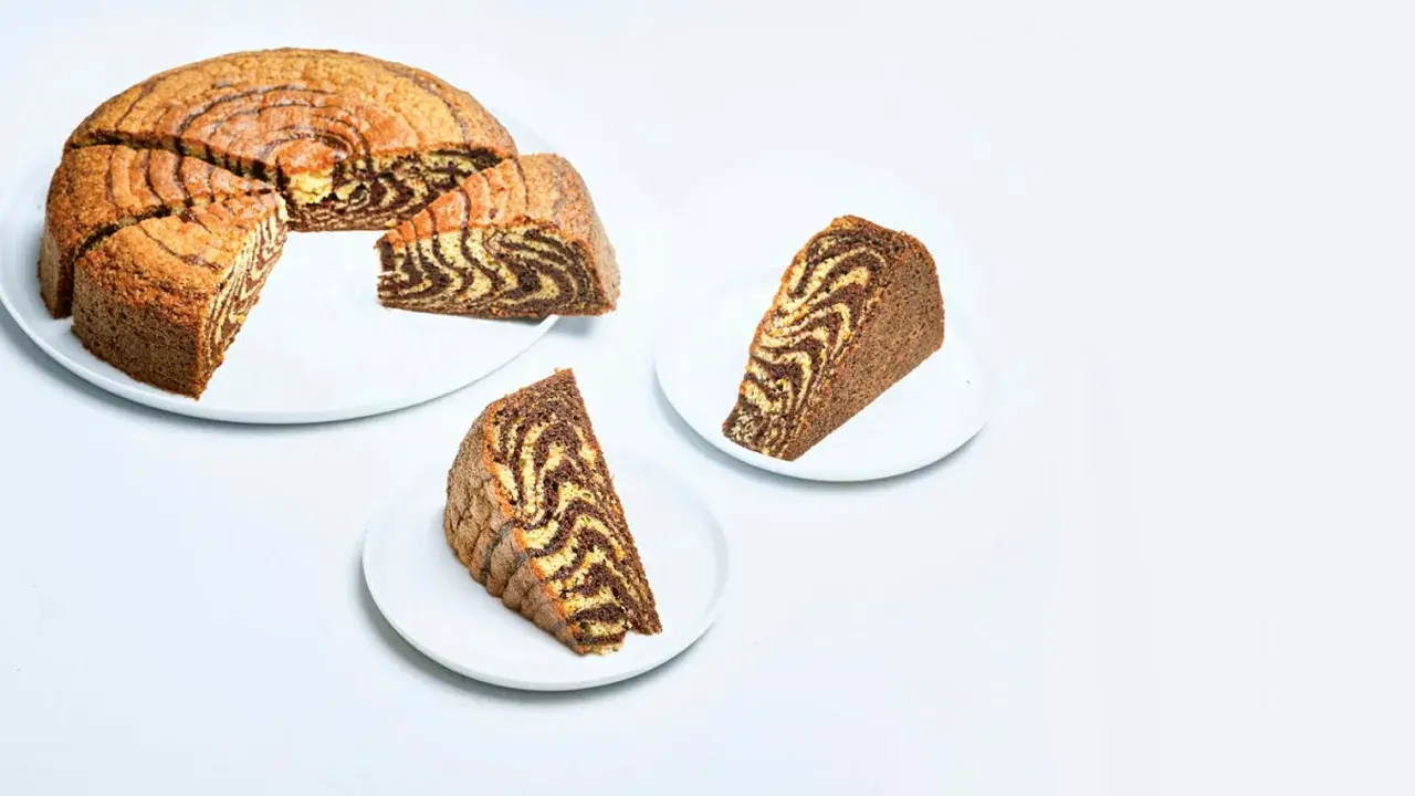 En saftig tigerkaka, skuren i bitar, visar upp sitt vackra marmorerade mönster. Ett perfekt tigerkaka recept för fikat.