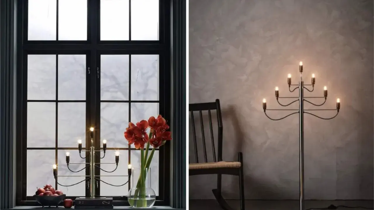 Två fina adventsljusstakar, en i ett mörkt fönster med amaryllis och äpplen, en annan som golvlampa bredvid en gungstol.