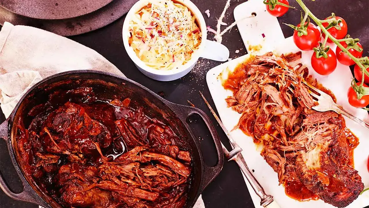 Saftigt pulled beef i en gjutjärnsgryta, serverat med krispig coleslaw och färska tomater. Perfekt för en mysig middag.