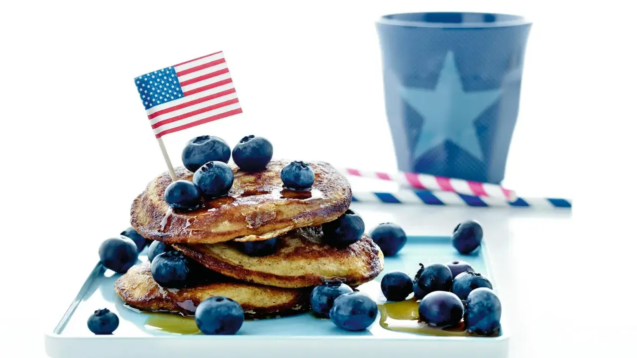 Amerikansk bananpannkaka recept med blåbär och en liten flagga. Perfekt för en festlig frukost!