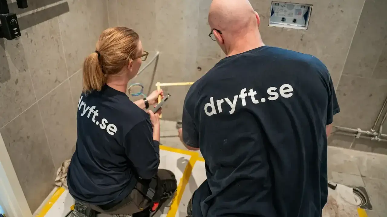 Två hantverkare från dryft.se mäter upp för att byta kommod i ett badrum.