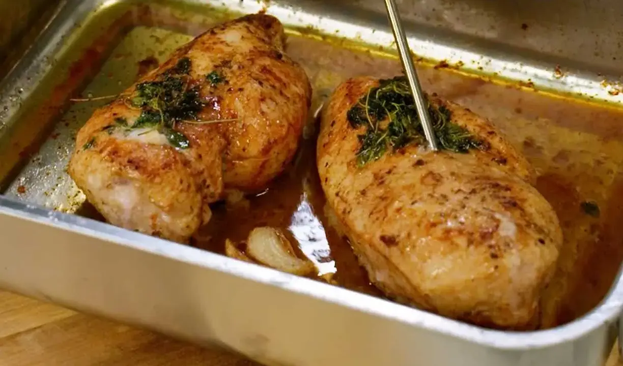 Två saftiga kycklinglårfiléer i ugnsform, en termometer visar att de är klara. Perfekt för ett gott kycklinglårfile recept.