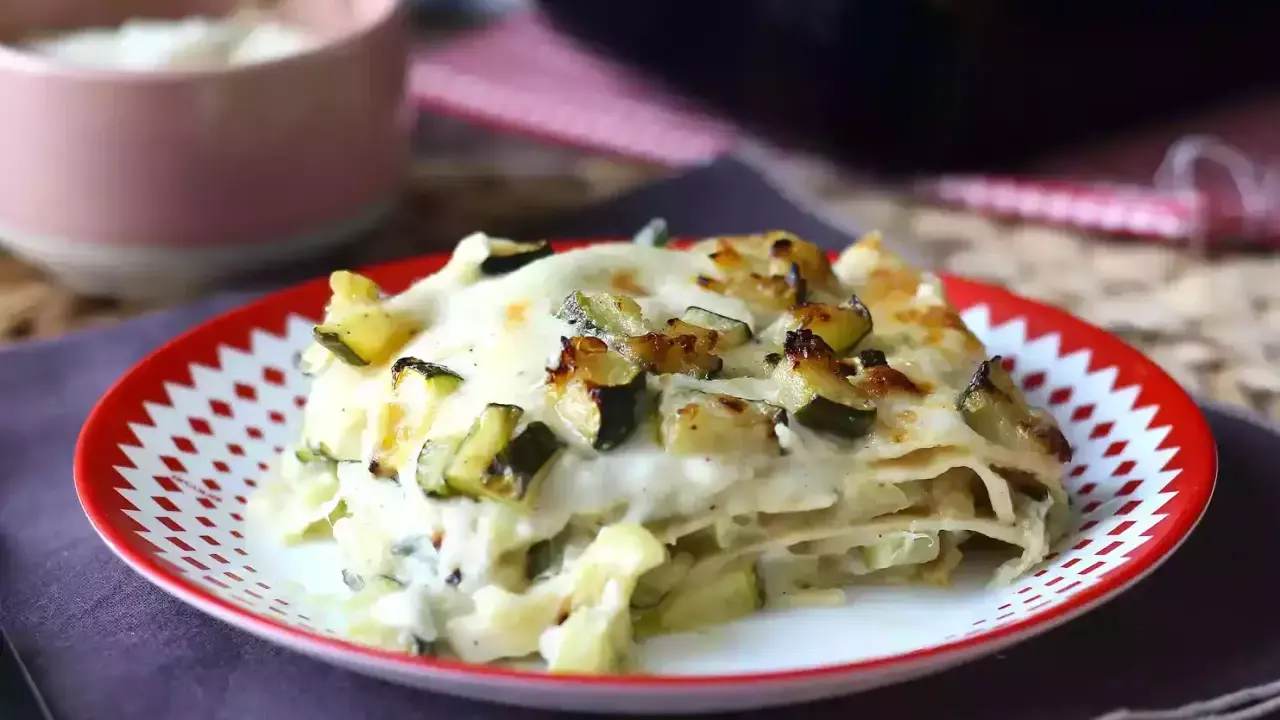 En portion krämig vegetarisk lasagne med zucchini, toppad med gyllene ost.