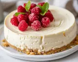 En krämig fryst cheesecake toppad med färska hallon och myntablad. Perfekt för en sommarfest.