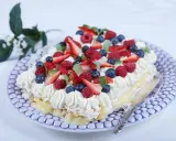 En vacker jordgubbstårta med grädde, bär och vaniljkräm. Perfekt för ett sommarfika, här är ett enkelt jordgubbstårta recept.