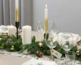 Vacker juldukning med granris, ljus och julgranskulor. En fin juldukning som skapar stämning.
