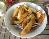 En skål med gyllene klyftpotatis i ugn, redo att serveras med en sallad och dipp. Perfekt tillbehör!