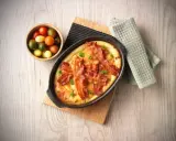 En härlig ugnspannkaka med knaprigt bacon, serverad med en skål körsbärstomater. Perfekt för en mysig frukost eller brunch.