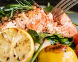 Saftig lax med citron och rosmarin, perfekt för ett enkelt lax recept. Serveras med körsbärstomater och gröna blad.