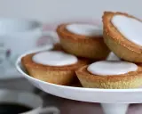 Små, gyllene mazariner med vit glasyr på ett fat. Perfekt för fikastunden, här är ett enkelt mazariner recept.