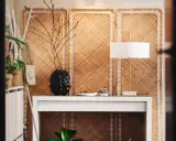 Skapa en mysig atmosfär och designa ditt rum med en vit hylla, en svart vas med grenar och en stilren lampa.