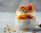 En läcker chiapudding med kvarg, apelsin och blodapelsin, toppad med pistagenötter.