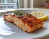 Saftig lax i airfryer, perfekt tillagad med krispig yta och toppad med färsk dill. Serveras med citronklyftor.