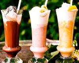 Tre läckra milkshakes i glas: choklad, jordgubb och aprikos. Perfekt för ett somrigt milkshake recept!