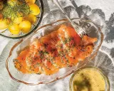 Gravlaxsås recept: Skivad gravad lax med dill, serverad med kokt färskpotatis och en skål med gravlaxsås.
