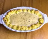 En gratinerad fiskrätt med alaska pollock recept, omgiven av spritsad potatis.