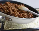 Köttfärs till tacopaj i långpanna. En sked ligger i pannan med den kryddiga färsen.