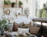 Mysig balkongdesign med kuddar, växter och en korgväska. En perfekt plats för avkoppling.
