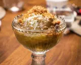 En skål med rabarberkompott och kardemumma, toppad med vaniljglass och smuldeg. En härlig dessert!