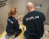 Två hantverkare från dryft.se mäter upp för att byta kommod i ett badrum.
