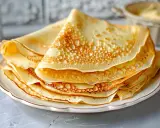 En hög med gyllene pannkakor, perfekta för ett enkelt pannkakor recept. De ser fluffiga och läckra ut, redo att serveras med sylt eller grädde.