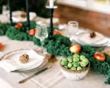 Vacker juldukning inspiration med grönt kale, äpplen och rosenkål. En rustik dukning som bjuder in till fest.