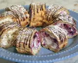 Budapestrulle recept: Skivade rulltårtor med grädde, bär och mandel, toppade med florsocker och chokladdrizzle.