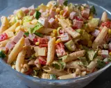 En stor skål med en härlig pastasallad med kassler, majs, tomat, gurka och en krämig dressing. Perfekt för sommaren!