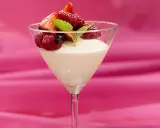 En elegant vit chokladmousse i ett martiniglas, toppad med färska bär och en myntakvist. En dröm för alla som älskar vit chokladmousse.