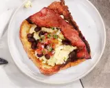 En tallrik med fattiga riddare toppad med äggröra, svarta bönor och salsa.