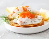 Toast Skagen med dill och rom på rostat bröd, garnerad med dillkvistar och citronklyftor.