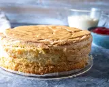 En fluffig tårtbotten, redo för fyllning. Perfekt för ditt tårtbotten recept. Bredvid syns grädde och sylt.
