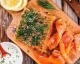 Njut av en bit gravad lax, toppad med dill och salt, serverad med citronskivor och en krämig sås.