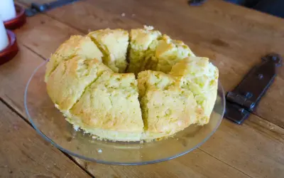 En saftig sockerkaka, uppskuren i bitar på ett fat, ligger på ett rustikt träbord.