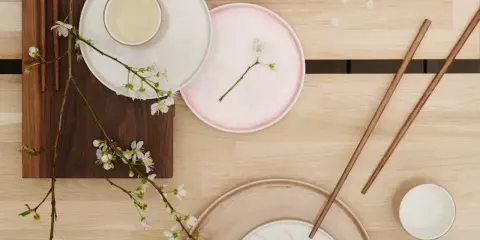 Vårens inspiration: tallrikar, ätpinnar och körsbärsblommor på träbord.