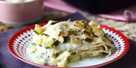 En portion krämig vegetarisk lasagne med zucchini, toppad med gyllene ost.