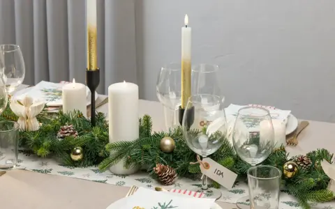Vacker juldukning med granris, ljus och julgranskulor. En fin juldukning som skapar stämning.