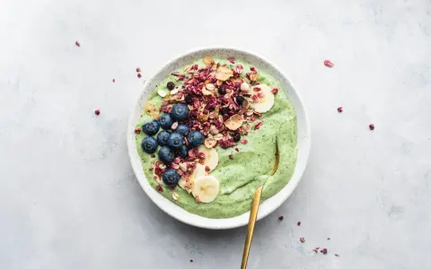 Grön smoothiebowl med blåbär, banan och granola. Perfekt för frukost tips!